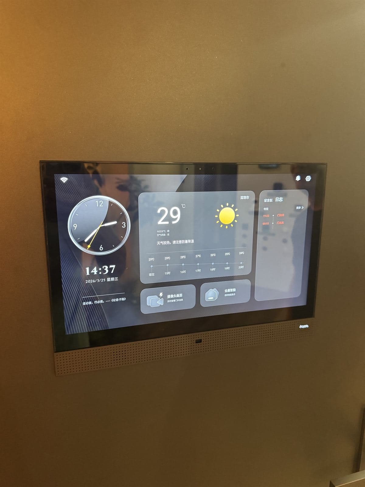 A wall-mounted Aqara smart-home control panel showing the time, weather and home controls, set into a bronze feature wall